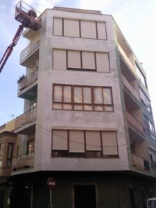 Saneado y preparación del soporte previa a la aplicación de pintura en fachada de Antonio Ribas de Palma. Trabajo con brazo articulado